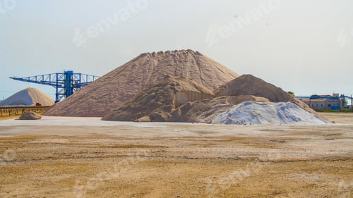 Preview: Blue crane in a quarry used for crushing sand for construction with a sandhill next to it