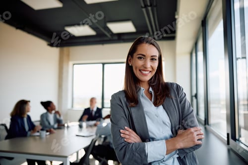 Preview: Young successful businesswoman at corporate office looking at camera.