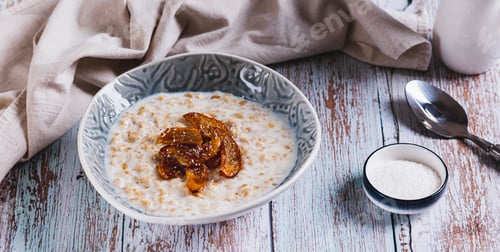 Preview: Oatmeal with caramelized apples and coconut flakes in a bowl on the table web banner