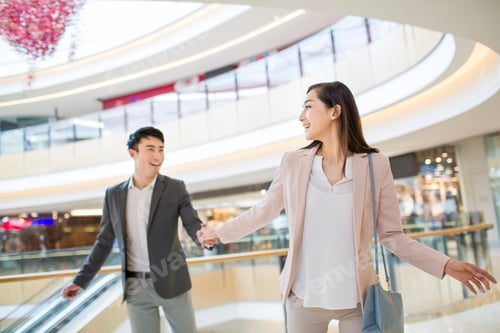 Preview: Young couple walking in shopping mall