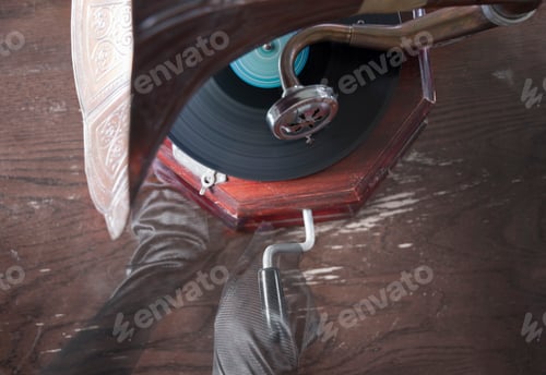 Preview: Ghostly hands in black gloves turn the handle of an old gramophone, Halloween