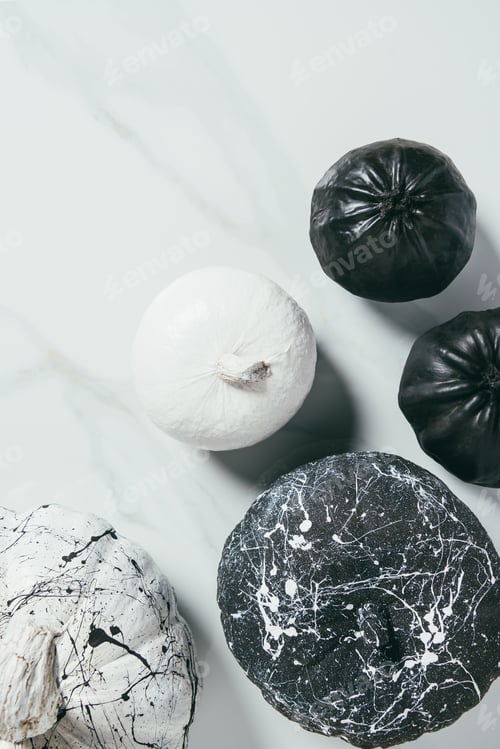 Preview: top view of decorative black and white pumpkins with paint splatters for halloween party