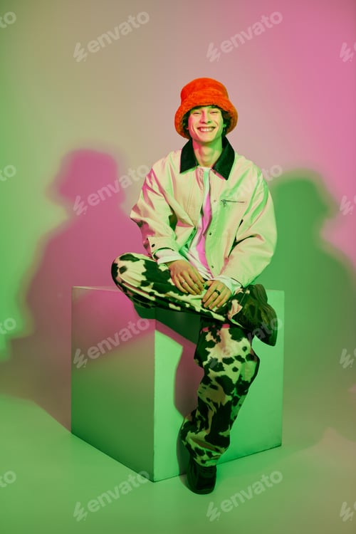 Vista previa: Young man showcases modern fashion in vibrant colors and stylish attire