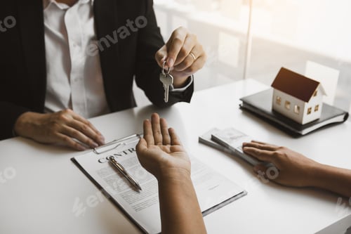 Preview: Hand of real estate agent passes the key to new homeowners in office with buyer house concept.
