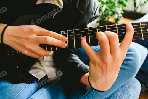 Preview: Electric guitar teacher teaching how to place fingers to play a chord.