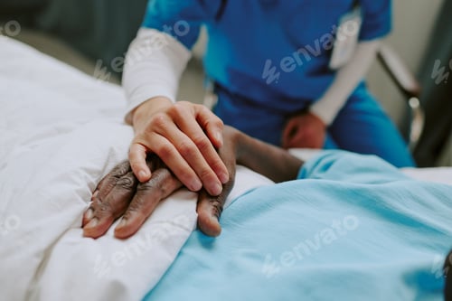 Preview: Holding Hands at Hospital Bedside with Patient Wearing ID Badge