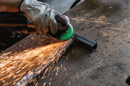 Preview: Male worker using electric grinder in workshop