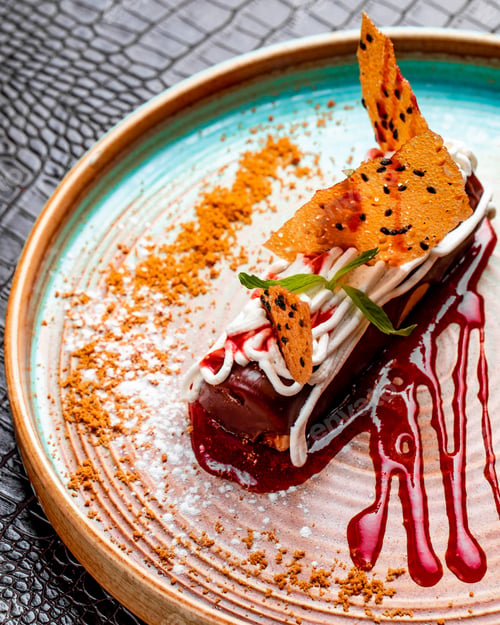 Preview: side view of chocolate eclair with whipped cream and strawberry on a plate