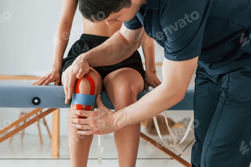 Preview: Physical Therapist Applying Kinesiology Tape on a Knee