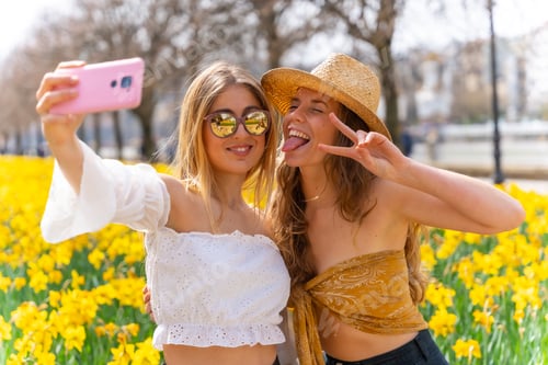 Preview: Friends on vacation in the city with straw hats next to some beautiful yellow