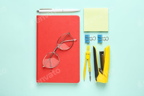 Preview: Flat lay composition with red notebook and office stationery on light blue background