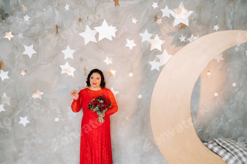 Preview: a woman in a red dress stands and holds a bouquet of red roses and strawberries in a fabulous studio