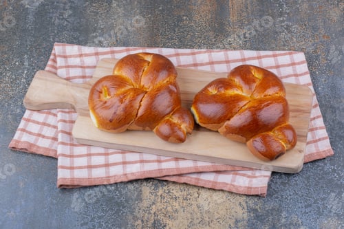 Preview: Two heart-shaped buns on a board on marble background