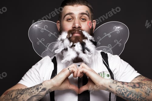 Preview: Funny bearded man with feathers and wings in the image of Cupid Valentine's Day.