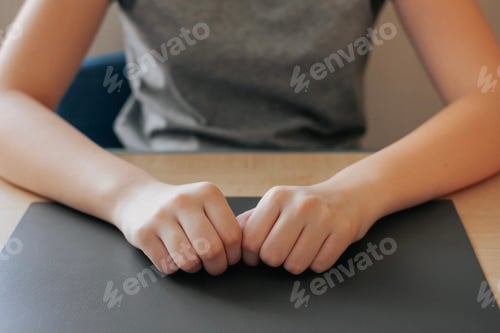 Preview: Teenage girl’s hands lying on an empty desk, table. Back to school ready for study minimal concept N