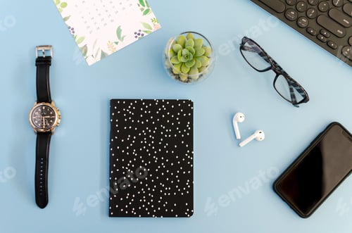 Preview: Overhead work space, flat lay desk items on a blue background