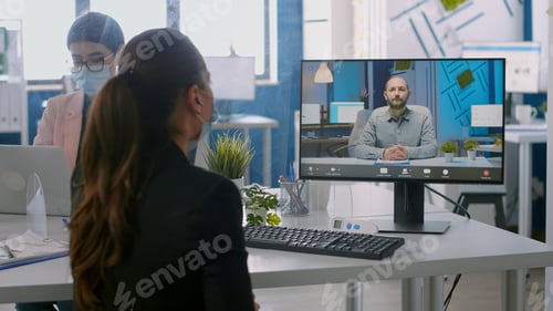 Preview: Back shot of businesswoman wearing medical face mask talking on videocall meeting