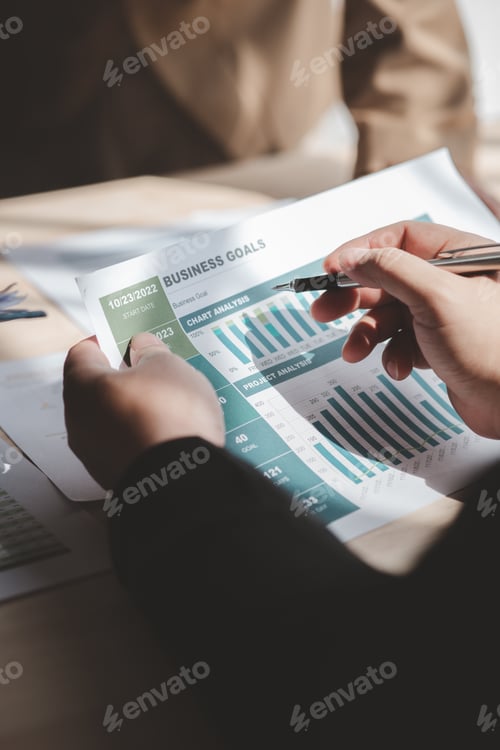 Preview: Businessman is reviewing monthly sales documents for analysis.