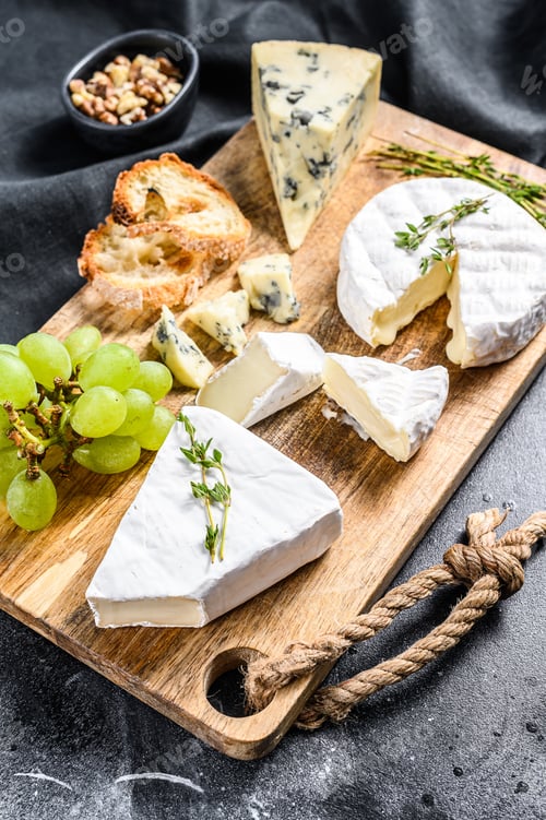 Preview: Cheese plate with Camembert, brie and blue cheese with grapes and walnuts.