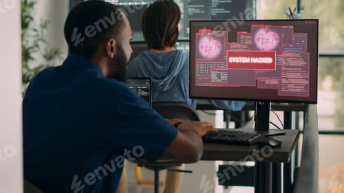 Preview: African american it engineer writing code encountering hacking alert on computer