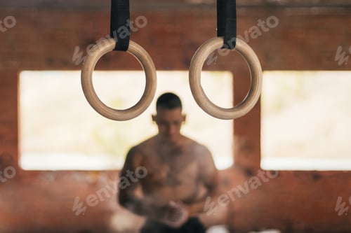 Preview: male athlete clapping with chalk in her hands. getting ready to train with gymnastic rings