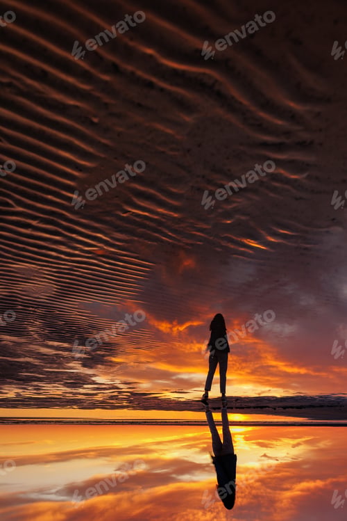 Preview: silhouette person against background beautiful sunset sky on ocean, reflection rays sun in water