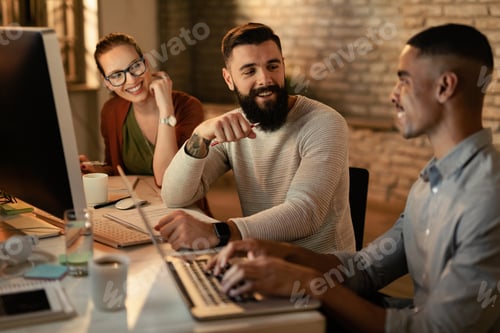 Preview: Group of happy colleagues talking while working in the office.