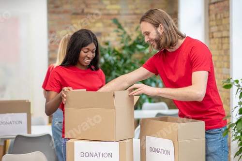Preview: Volunteers in red thsirts taking part if donations distribution