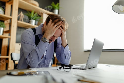 Preview: A photo of a tired architect taking off his glasses and holding his hands on his head.