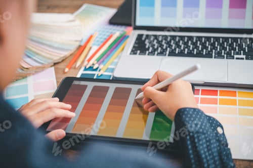 Preview: Graphic designer architects who work with laptops and color comparison tables for design work.