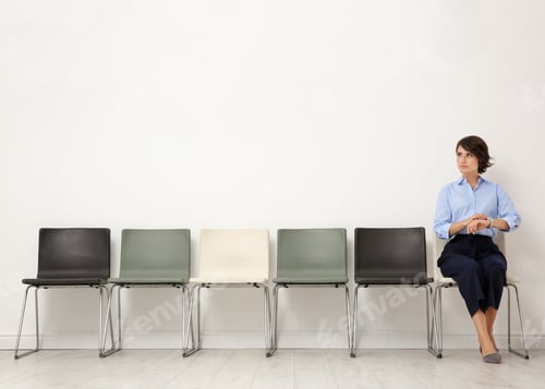 Preview: Young woman sitting on chair and waiting for job interview