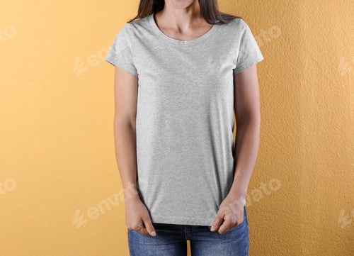 Preview: Young woman in grey t-shirt on color background. Mockup for design