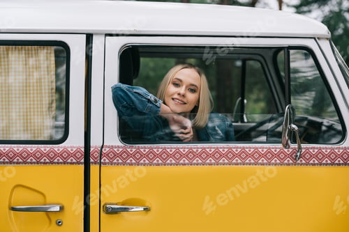 Preview: attractive blonde girl sitting in retro styled minivan