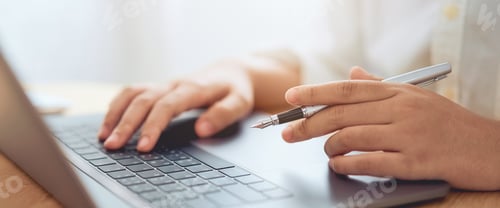 Preview: Businessman hands using laptop computer with holding pen and learning various course from online.