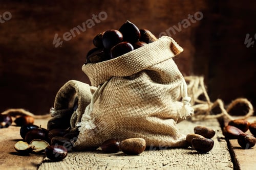 Chestnuts spilling out of rustic burlap bag
