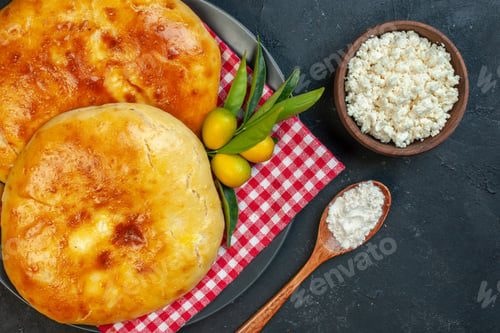 Preview: Close up view of delicous fresh baked pastries kumquats with stem on red stripped towel and cheese