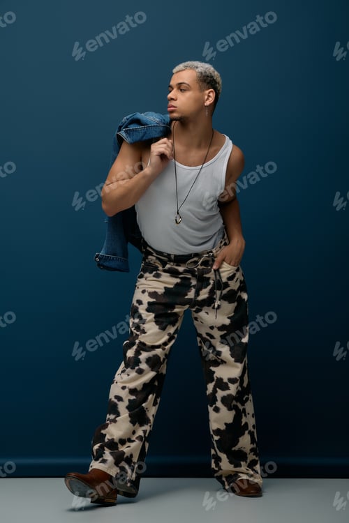 Preview: Young african american man shines in stylish denim jacket against deep blue background