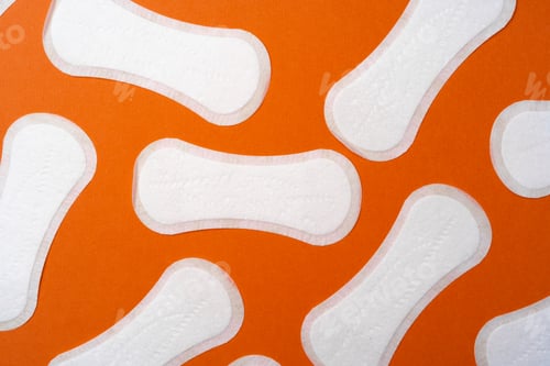 Preview: Woman hygienic pads on orange background top view