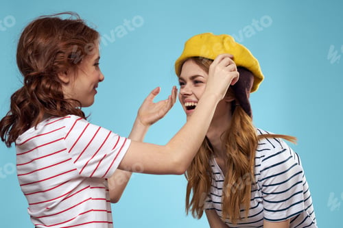 Preview: Fashion sisters in hats fun lifestyle blue background studio