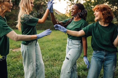 Preview: Happy volunteers giving high five after cleaning park