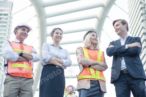 Preview: Successful group of businessmen and engineers with arms crossed at outdoor.