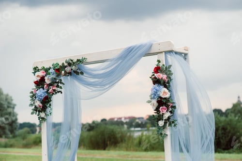Preview: Wedding ceremony on the street on the green lawn.Decor with fresh flowers arches for the ceremony