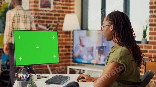 Preview: Corporate worker looking at greenscreen display on computer
