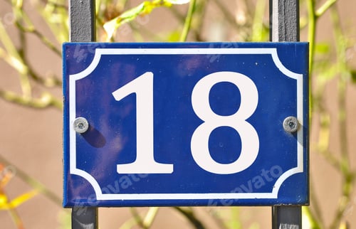 Preview: Closeup shot of a blue sign with the number 18 on the blurry background