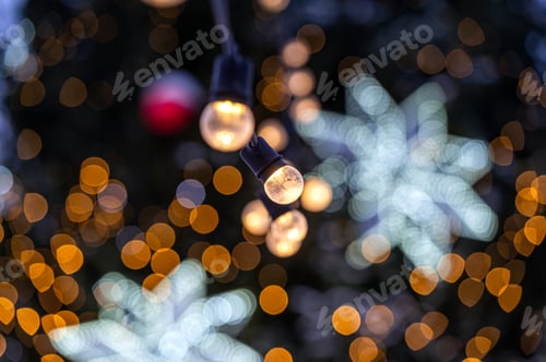 Preview: Outdoor decorated Christmas tree with light garland, selective focus
