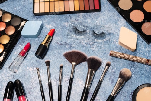 Preview: Various makeup products, brushes on blue background