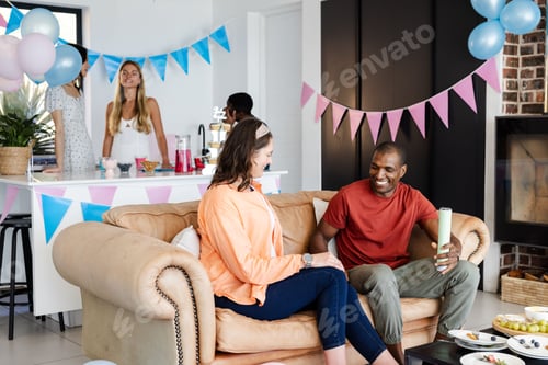 Preview: Friends enjoying casual gathering at home with festive decorations and snacks