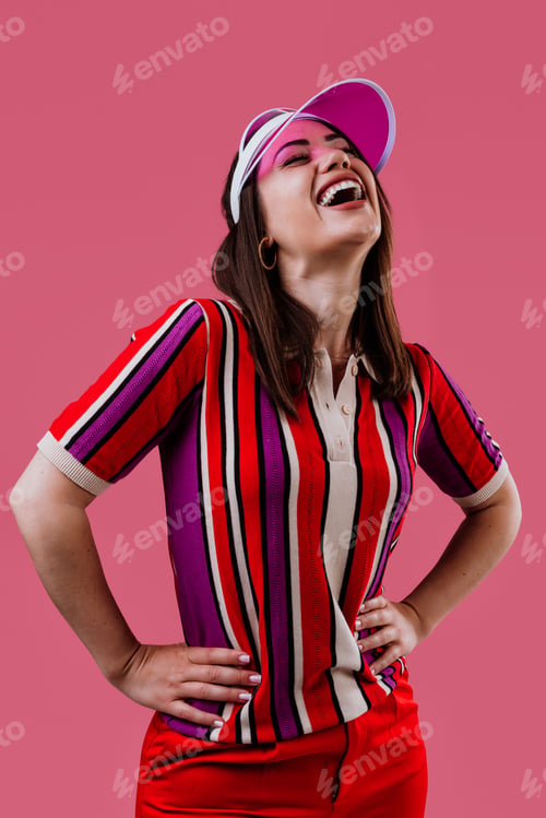 Preview: Woman wearing vibrant striped polo and pink visor