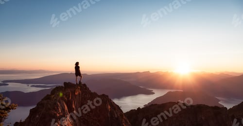 Preview: Adventurous Caucasian Woman Hiking on top of a Rocky Mountain Cliff