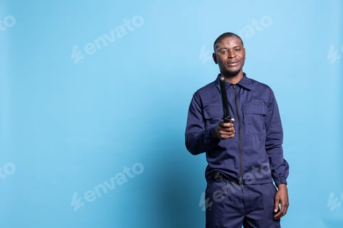 Preview: Male security agent posing with his police baton on camera,
